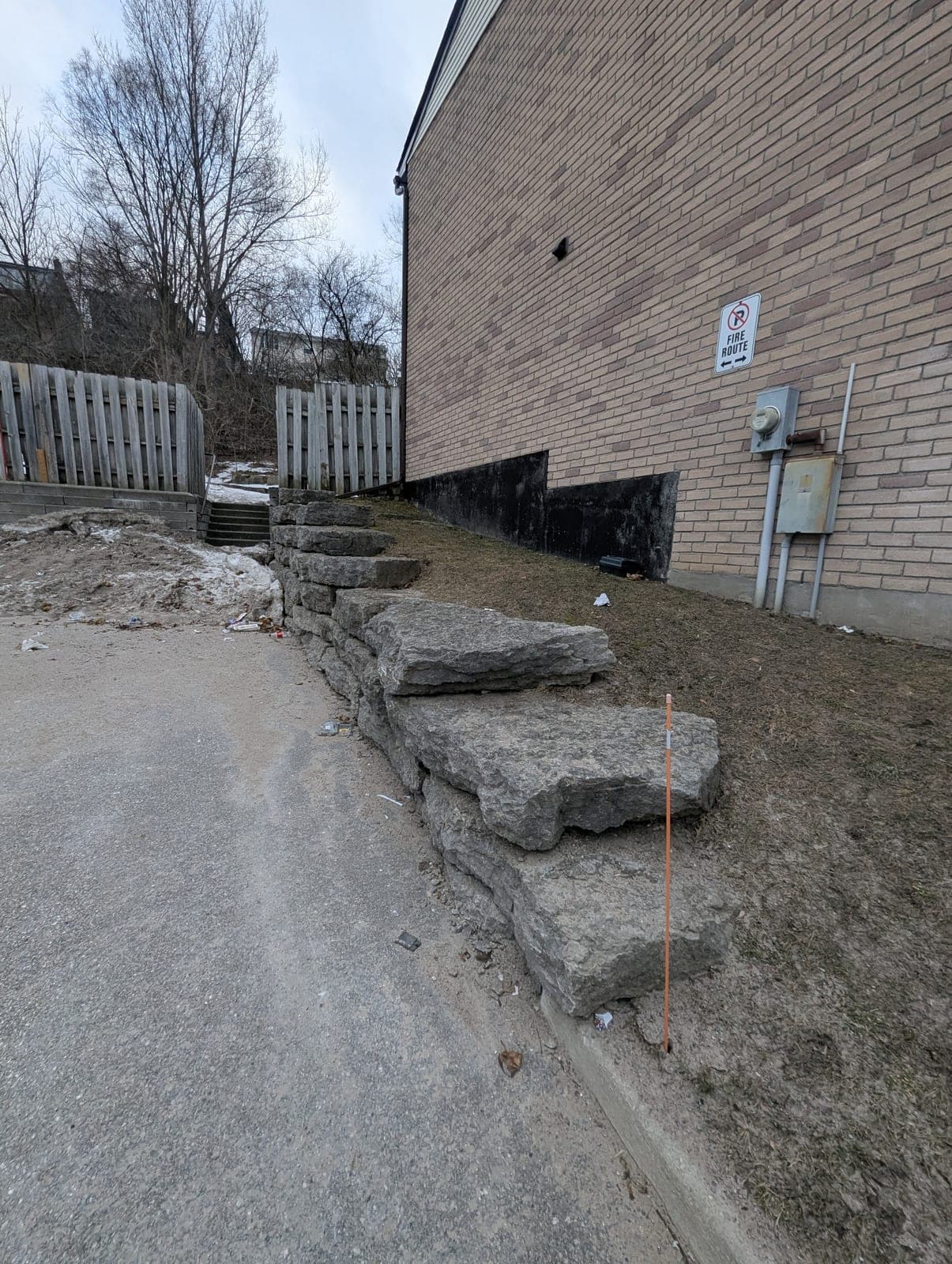 Armour stone retaining wall with integrated stone steps beside a commercial building