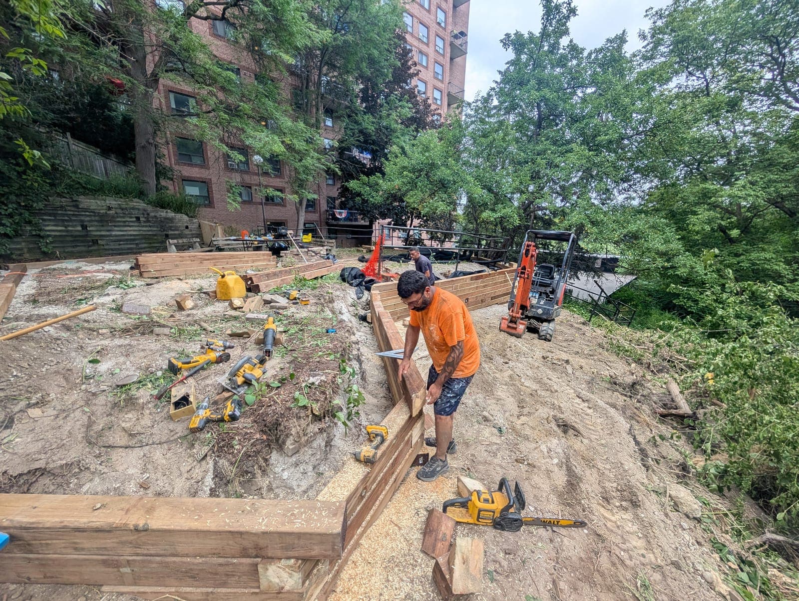 Landscaper building a timber retaining wall to terrace a steep slope