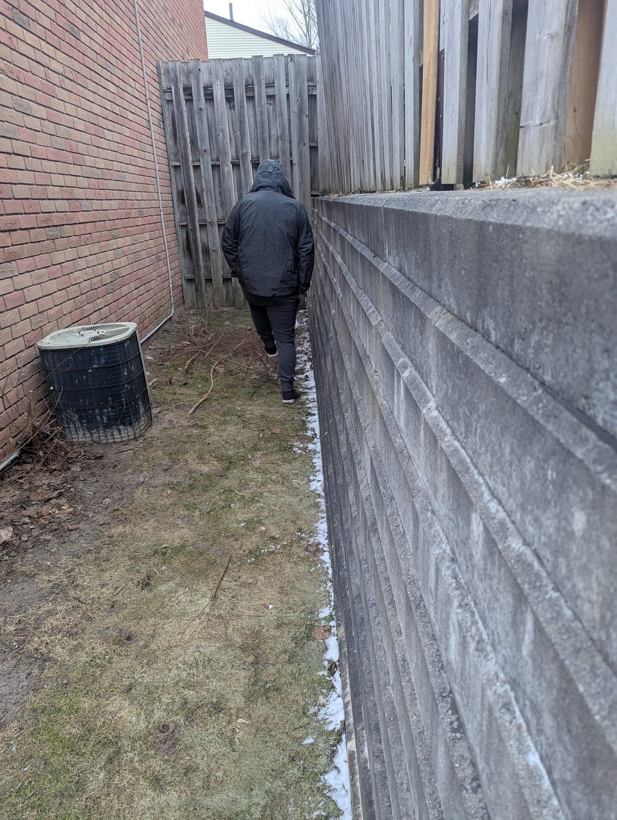 Tall segmental concrete block retaining wall in a narrow side yard corridor