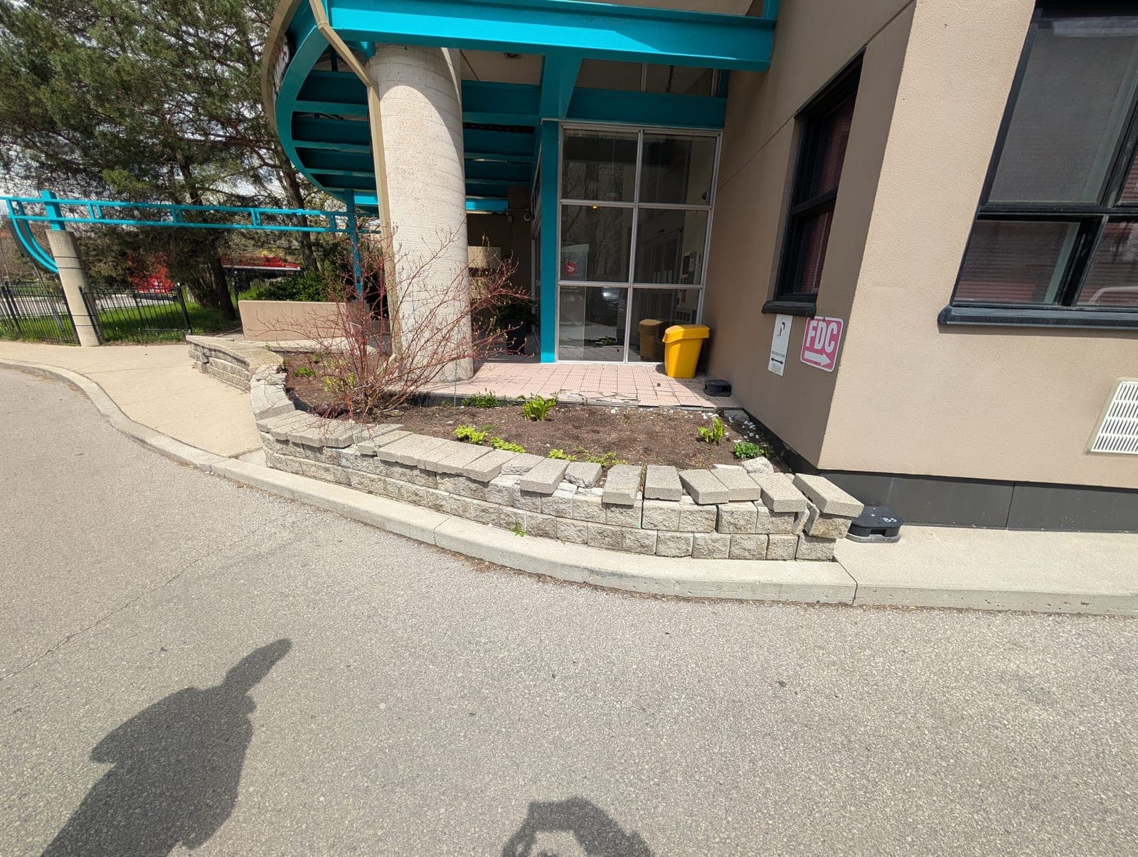 Curved segmental block retaining wall forming a raised planter bed at a commercial entrance
