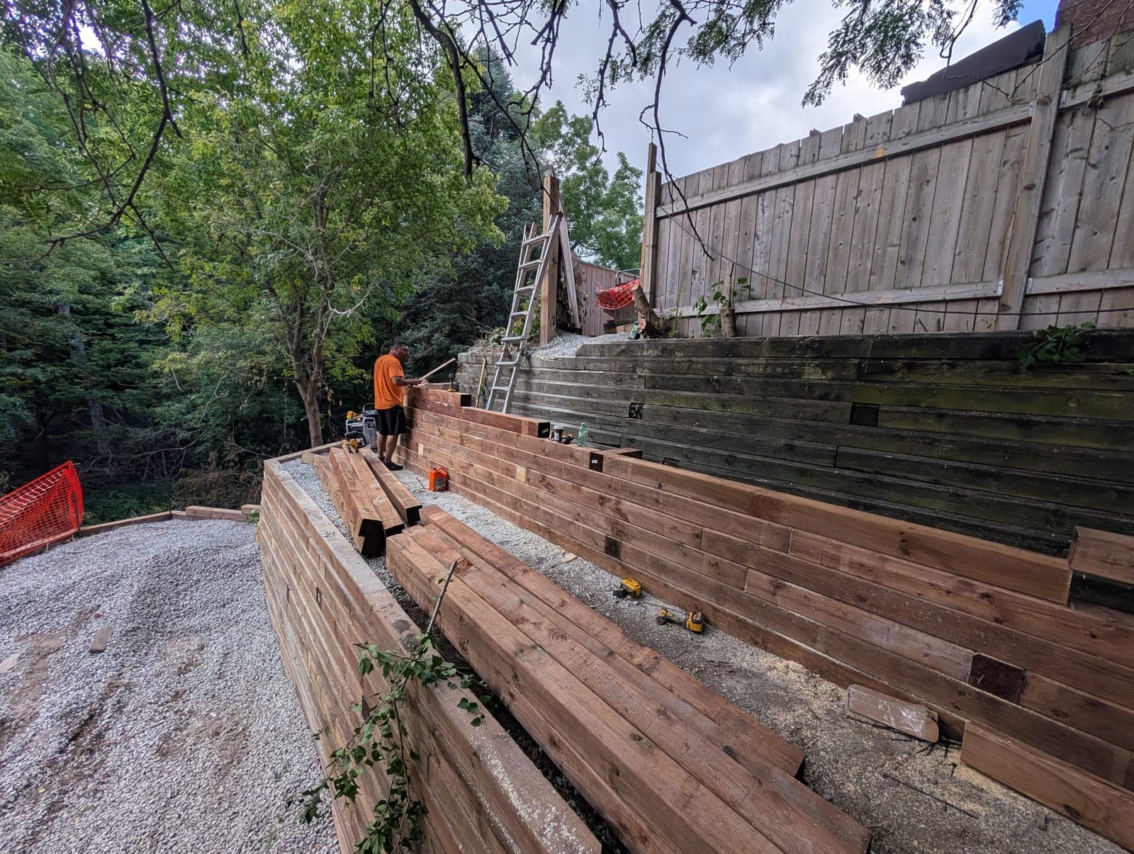 Long tiered timber retaining wall running along a landscaped hillside slope