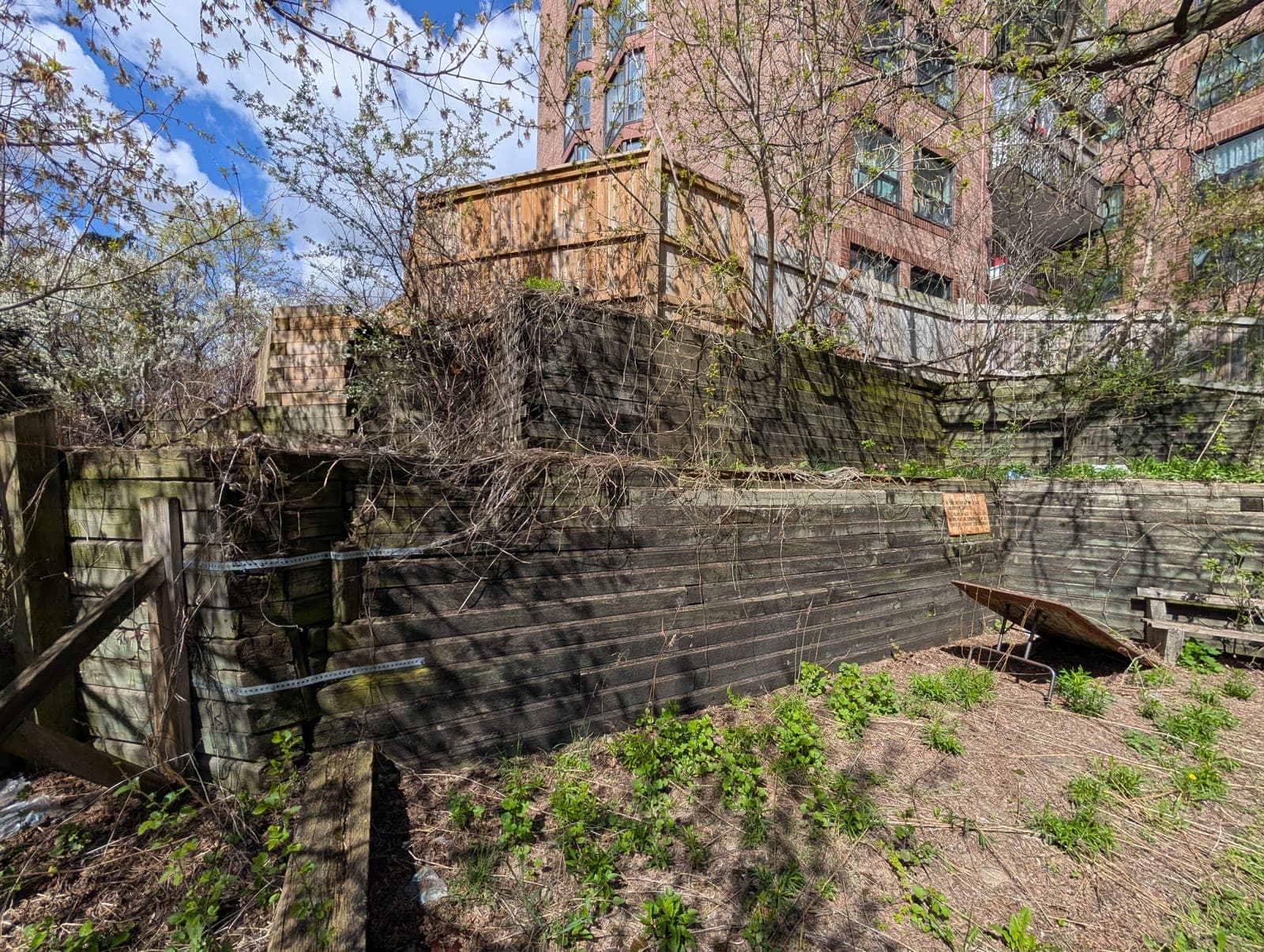 Multi-tiered timber retaining wall system holding back a steep landscaped grade