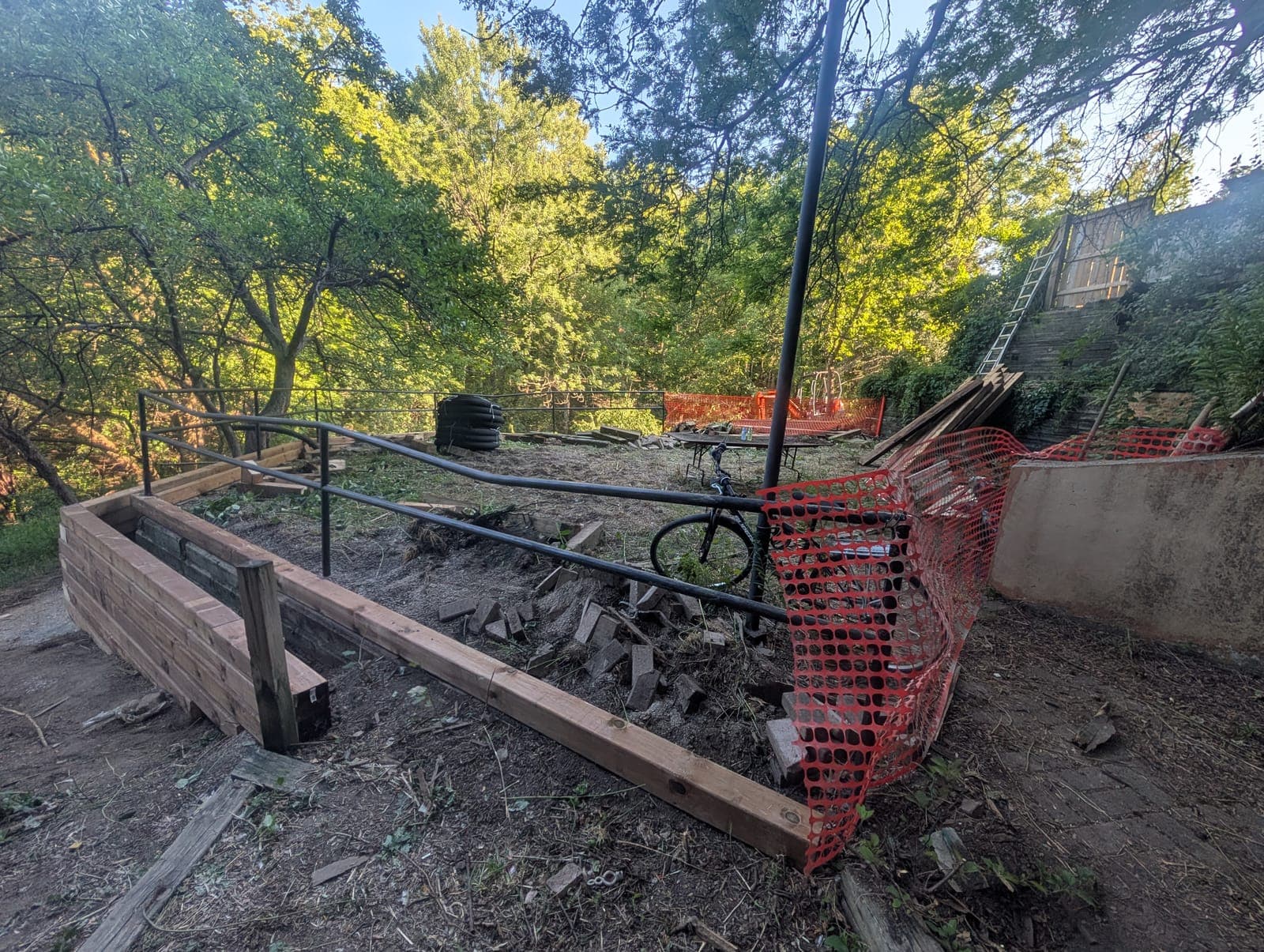 New timber retaining wall forming a raised terrace with railing during construction