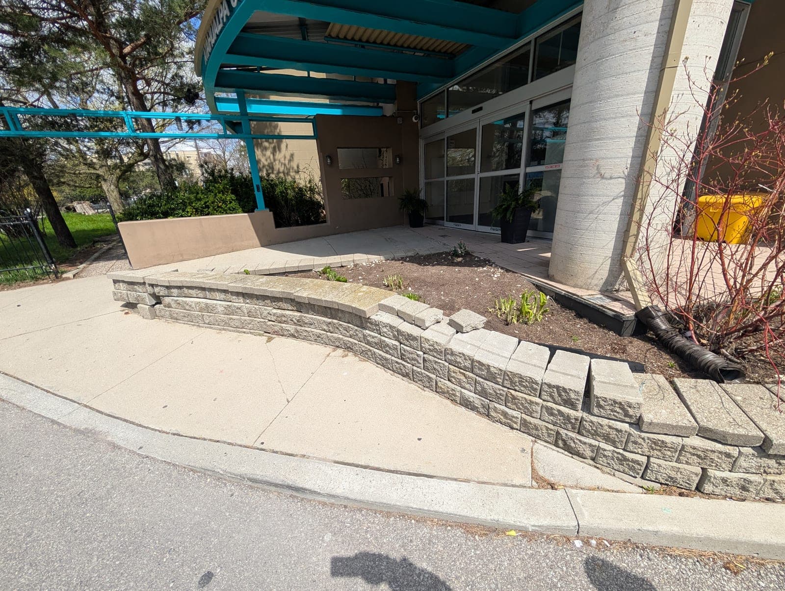 Segmental block retaining wall creating a raised garden bed at a building entrance