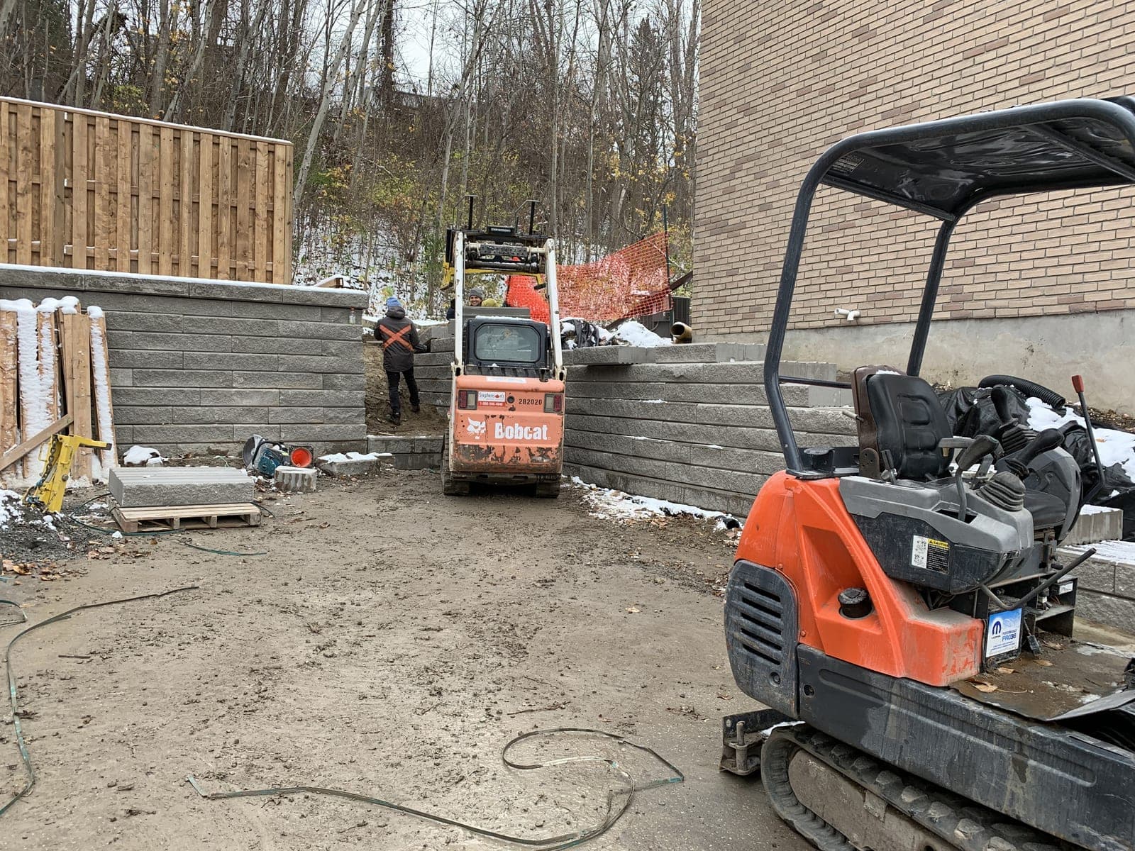 Corner segmental block retaining wall during a backyard hardscape installation