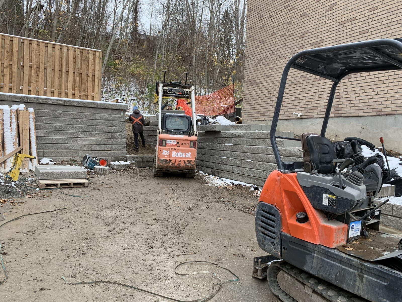 L-shaped segmental block retaining wall lining a backyard patio area