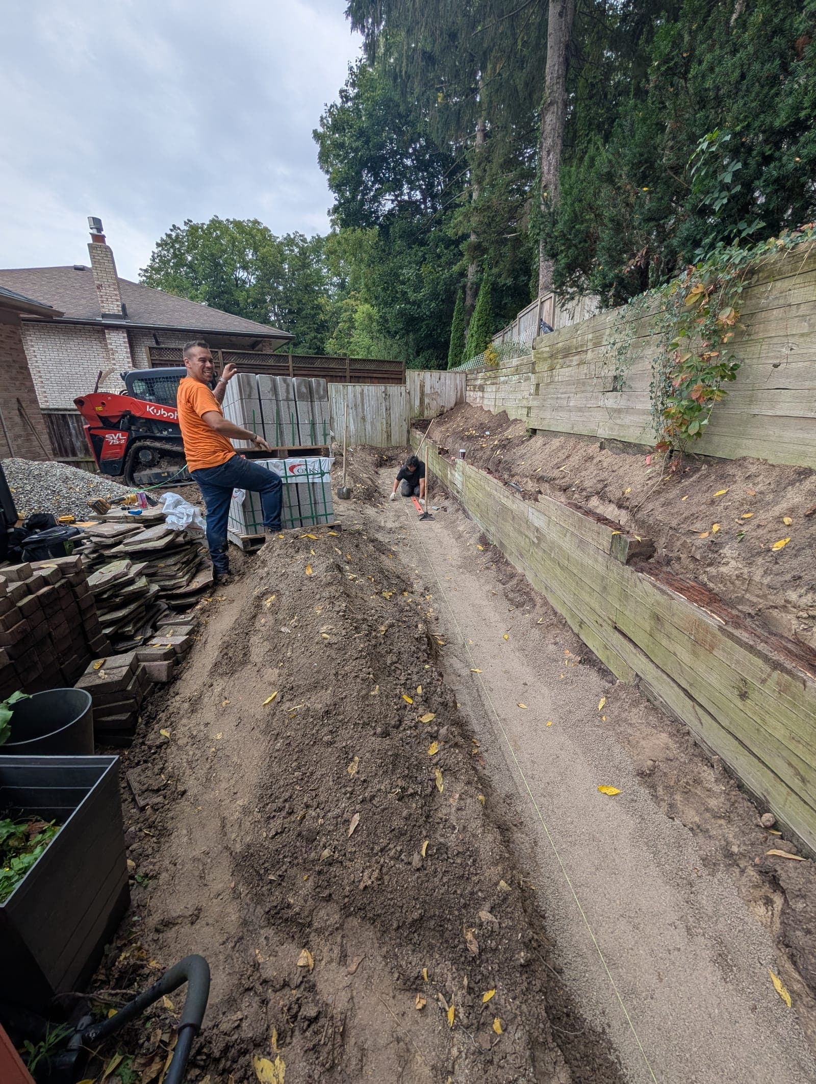 Tall timber retaining wall holding back a landscaped slope along a backyard property line