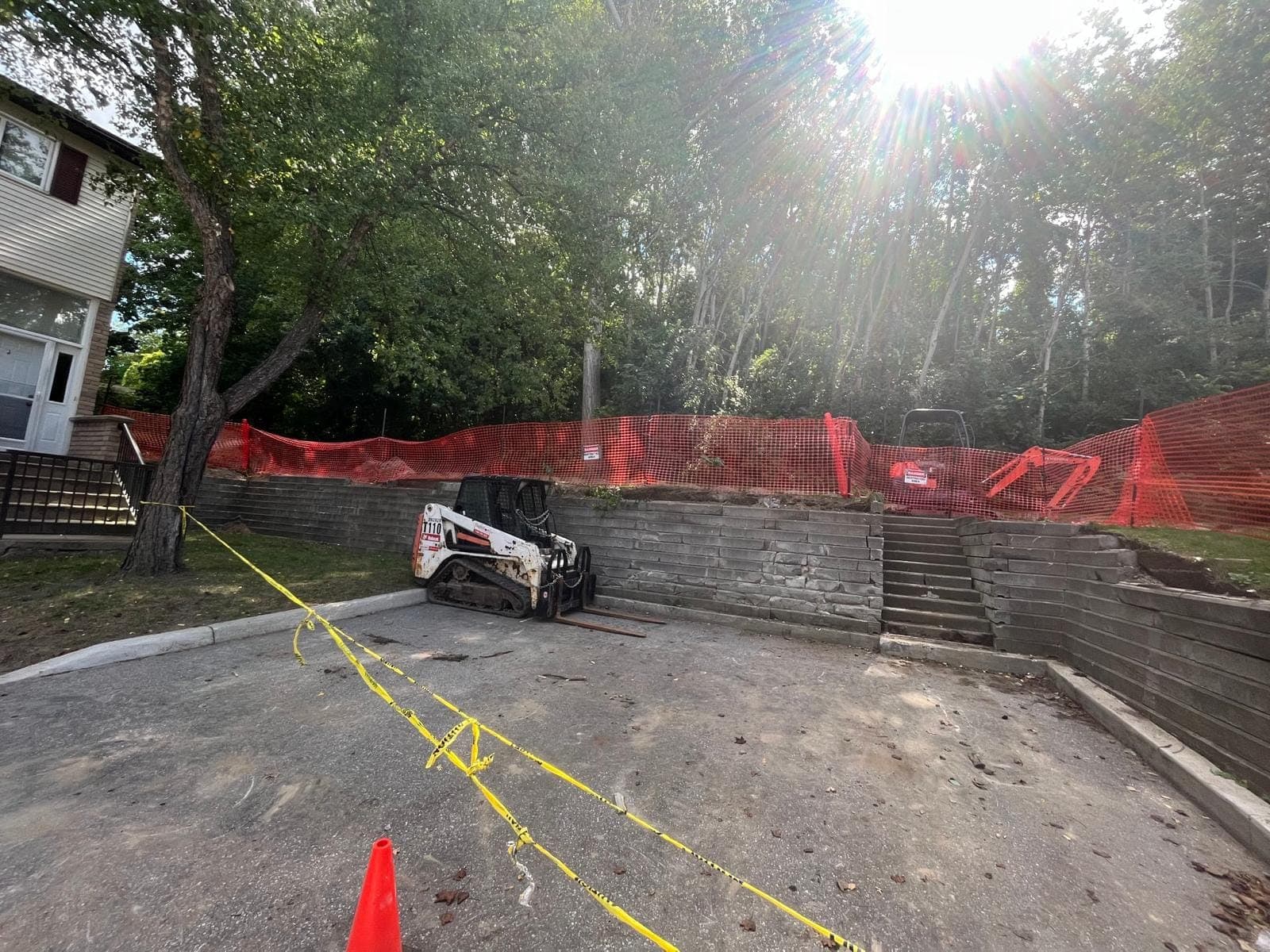 Terraced segmental block retaining walls with steps beside a new parking pad