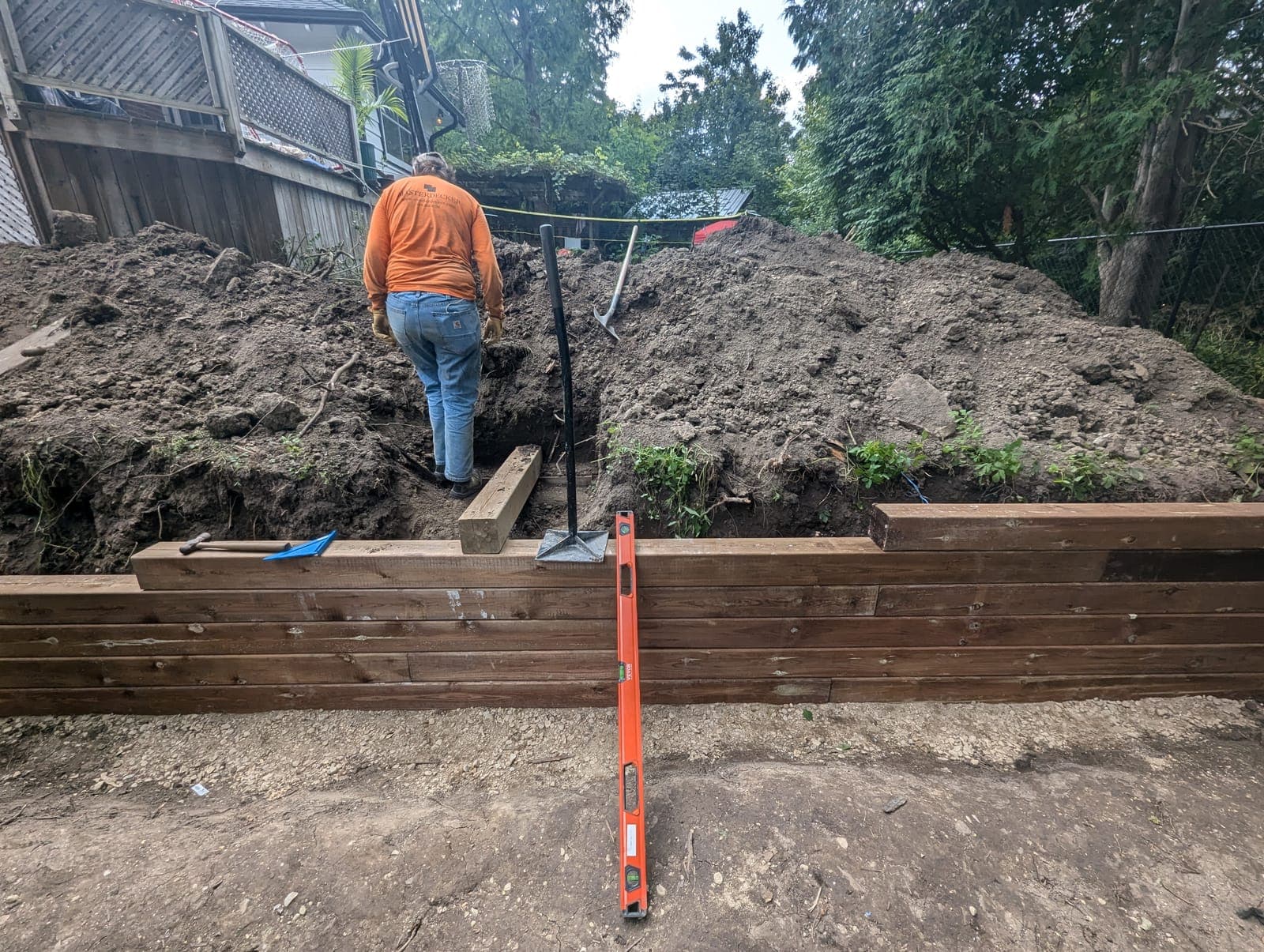 Terraced pressure-treated timber retaining wall built into a sloped backyard grade
