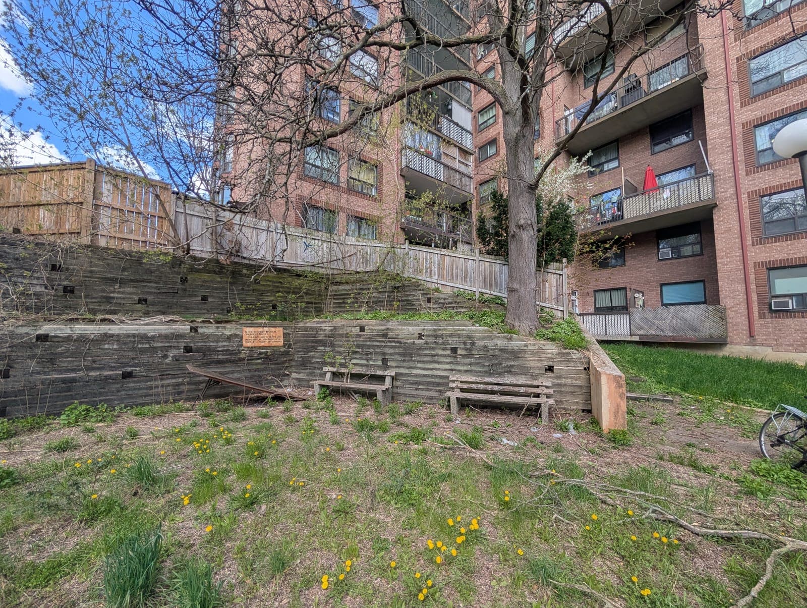 Tiered timber retaining wall with built-in bench seating on a landscaped slope