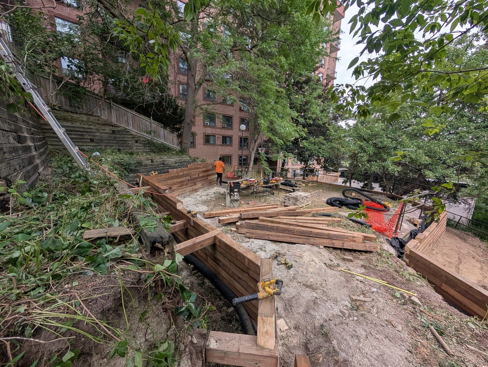 New timber retaining wall under construction terracing a sloped urban backyard