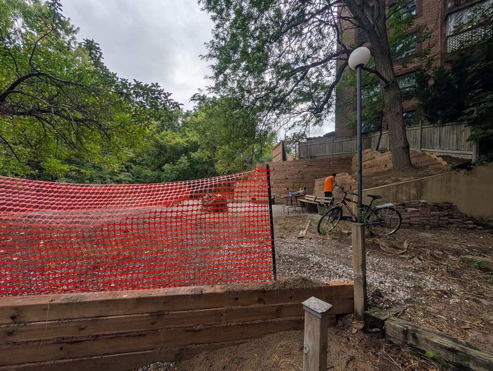 Timber retaining wall topped with safety fencing beside terraced timber walls in an urban backyard