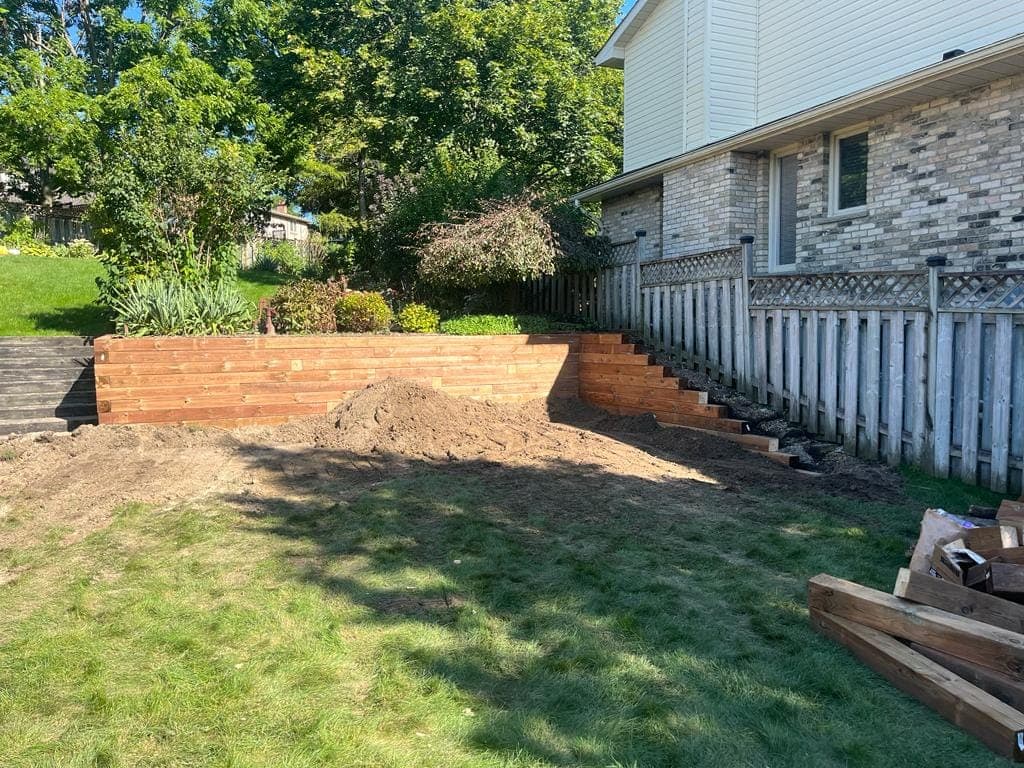 Cedar timber retaining wall with side steps holding back a landscaped garden bed