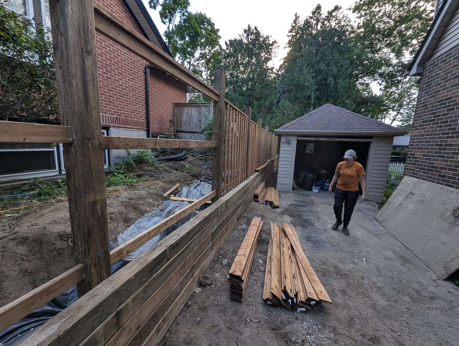 Wood timber retaining wall holding back the grade between a driveway and side yard
